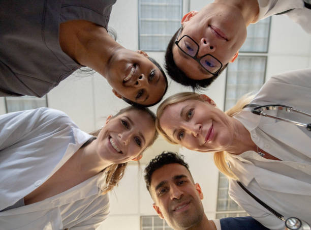 istock Multi-ethnic group of medical professionals looking down at camera 1241965927