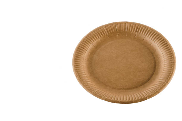 istock Eco natural plate with empty space. Disposable ecological utensils on white background. Sustainability of planet. Closeup isolated cardboard plate made of fiber of bamboo and bagasse. 1241977574