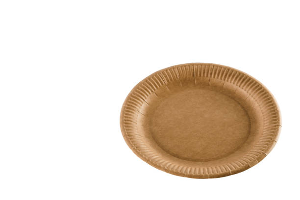 istock Eco natural plate with empty space. Disposable ecological utensils on white background. Sustainability of planet. Closeup isolated cardboard plate made of fiber of bamboo and bagasse. 1241977590