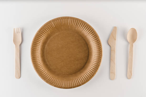 istock Eco natural plate with spoon, knife, fork with empty space. Disposable ecological utensils on white background. Sustainability of planet. Cardboard plate made of fiber of bamboo and bagasse. 1241977609