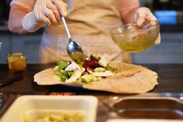 istock woman fills and rolls a vegetable wrap 1241982475