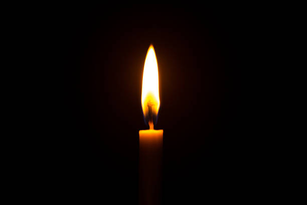 istock Close up single candle light and flame on black backgrou 1241990641