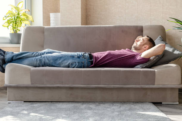 istock young man resting lying on a sofa in a bright room 1241994323