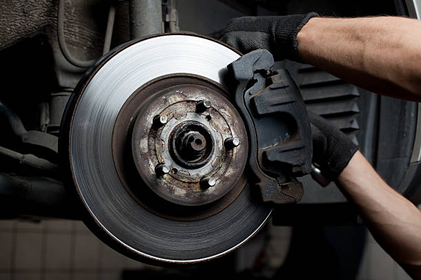 A mechanic working on a brake pad  stock photo