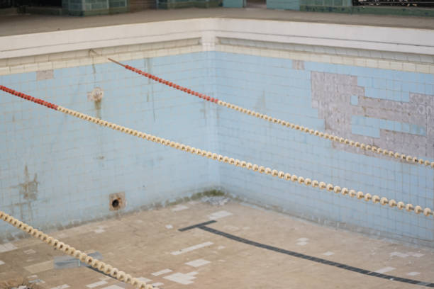 Detail of abandoned imperial times swimming bath, light blue tiled deep pool with separating floating leads stock photo