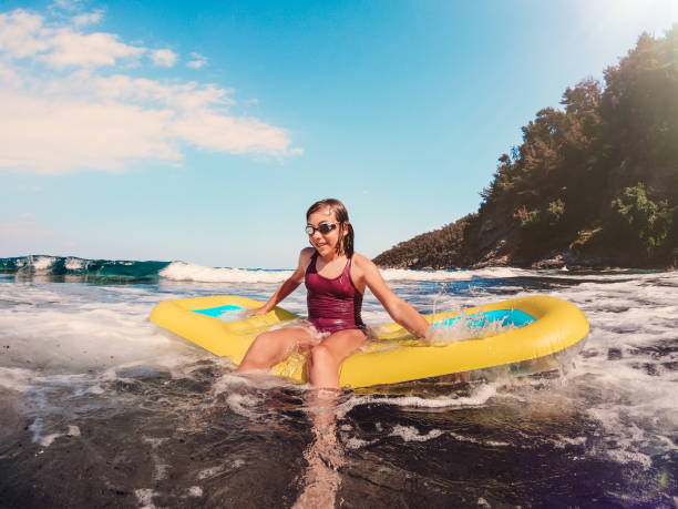 fille jouant dans la mer avec le matelas d’air - child nautical vessel summer swimming goggles photos et images de collection