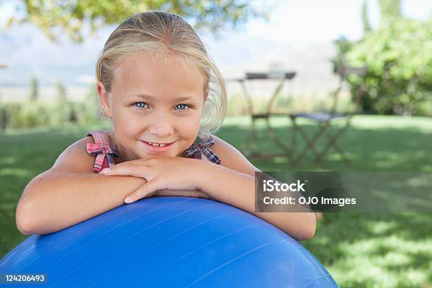 Carina Ragazza Sorridente Dietro A Fitness Palla In The Grass - Fotografie stock e altre immagini di 6-7 anni