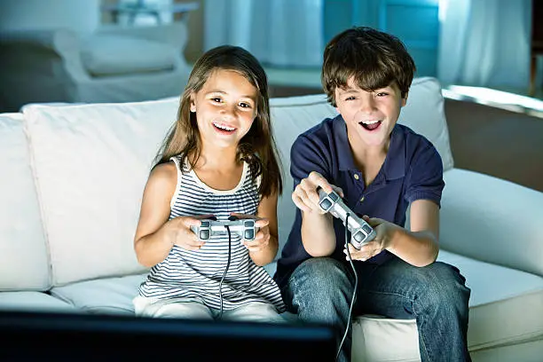 Photo of Children playing video game at home