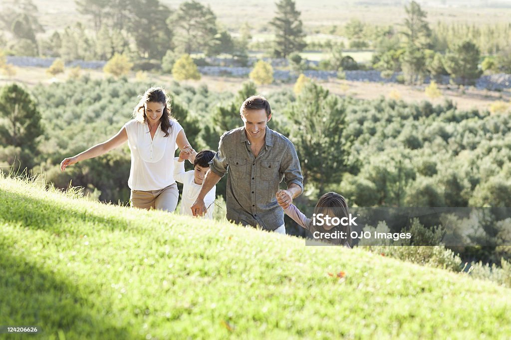 Glückliches Paar mit Kindern Hände halten und zu Fuß in - Lizenzfrei 35-39 Jahre Stock-Foto