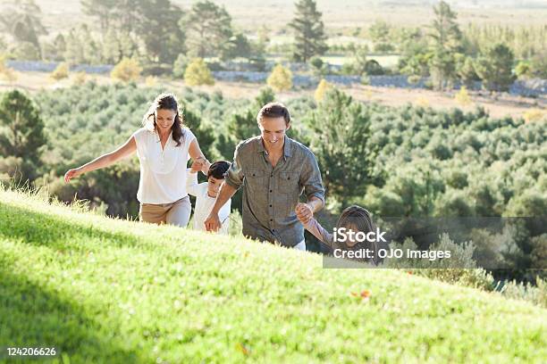 Pareja Feliz Con Niños De Las Manos Y Caminar En La Retención Foto de stock y más banco de imágenes de 30-39 años