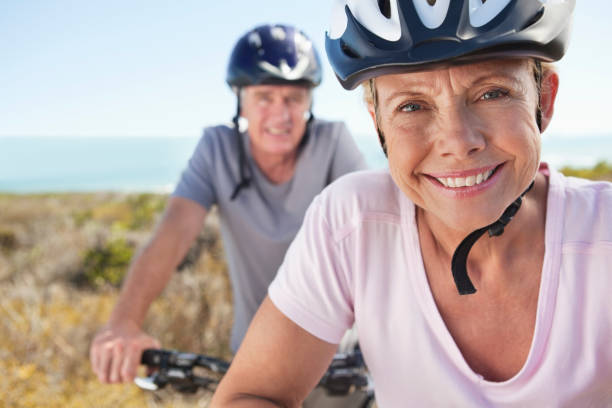 portret starszych kobieta w kask sportowy uśmiechając się - cycling senior adult sports helmet men zdjęcia i obrazy z banku zdjęć