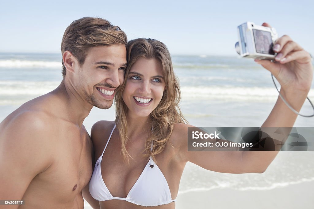 Красивая молодая пара, получающих Сам Портрет на пляже - Стоковые фото Друг - бойфренд роялти-фри