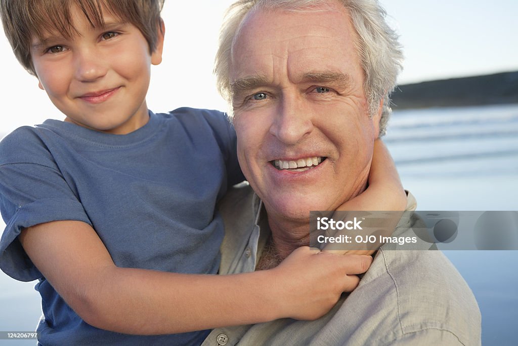 Gros plan d'homme senior s'amuser avec son petit-fils sur la plage - Photo de Famille libre de droits