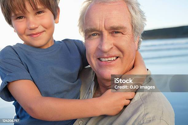 Close Up Of Senior Man がビーチでの楽しい孫 - バケーションのストックフォトや画像を多数ご用意 - バケーション, 家族, 2人