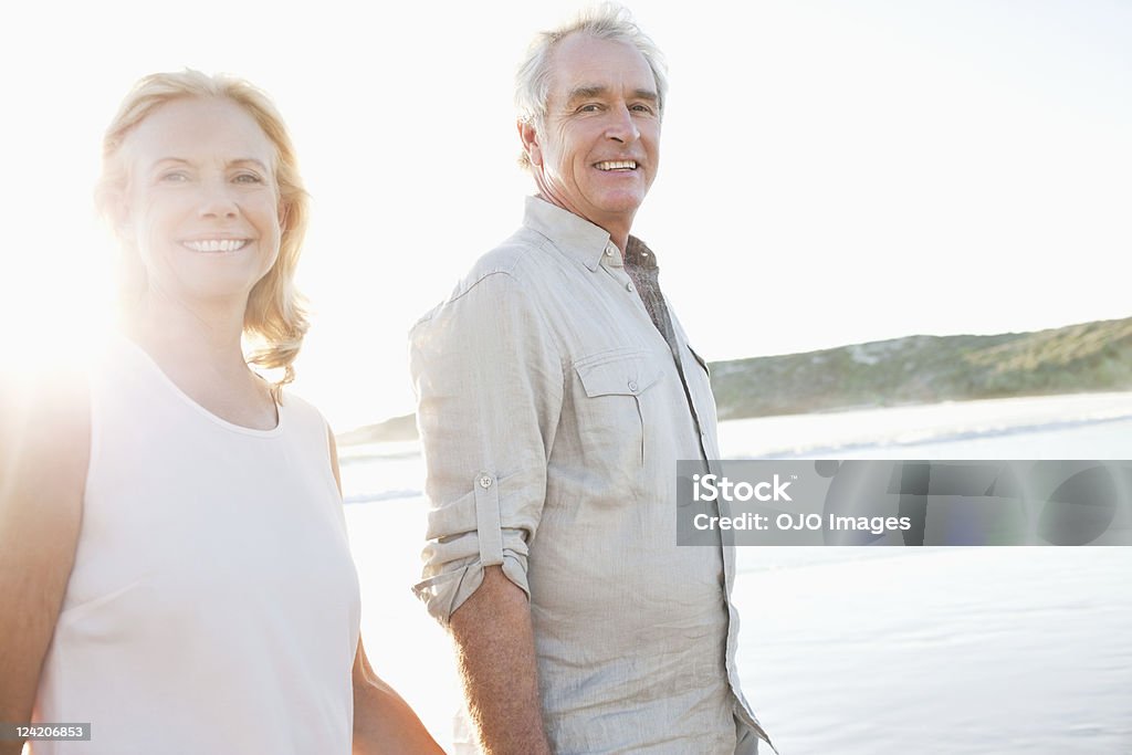 Coppia felice sorridente sulla spiaggia - Foto stock royalty-free di Camminare