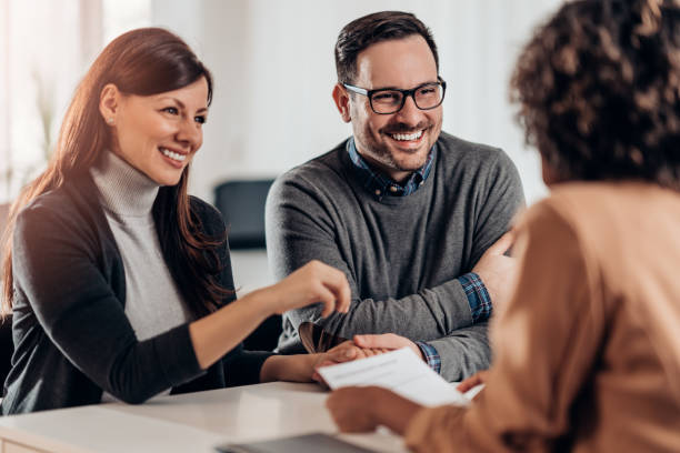 istock Happy couple talking with sales manager 1242080583