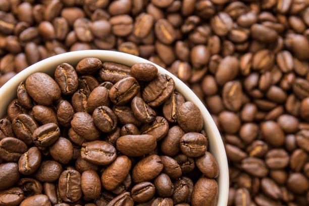 Large white cup of roasted coffee beans stock photo