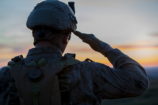 soldier saluting at sunset