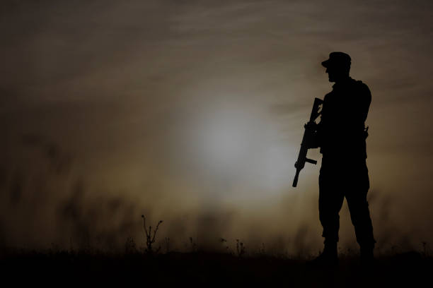 istock silhouette of soldier standing at sunset 1242121712