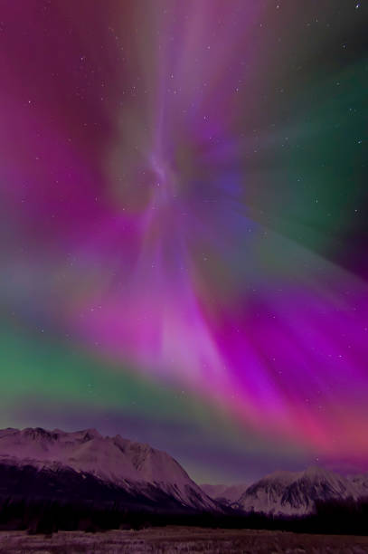 The aurora borealis is a natural light display in the sky particularly in the high latitude of the Arctic regions, caused by the collision of energetic charged particles with atoms in the high altitude atmosphere (thermosphere). Major solar flare causing The aurora borealis is a natural light display in the sky particularly in the high latitude of the Arctic regions, caused by the collision of energetic charged particles with atoms in the high altitude atmosphere (thermosphere). Major solar flare causing great Aurora borealis over Kluane National Park, Yukon, Canada. Coronas form of aurora. aurora borealis orange stock pictures, royalty-free photos & images
