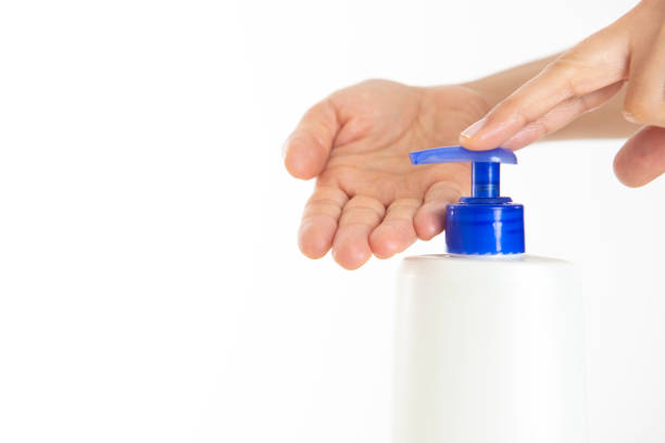 Woman hands pouring moisturising cream from dispenser.