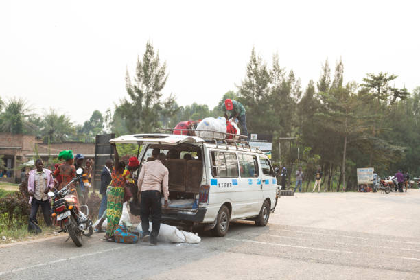 Ntandi, Uganda - January 24th, 2020: Unidentified people get off a minibus on a road in Ntandi, Uganda. Minibus (local \