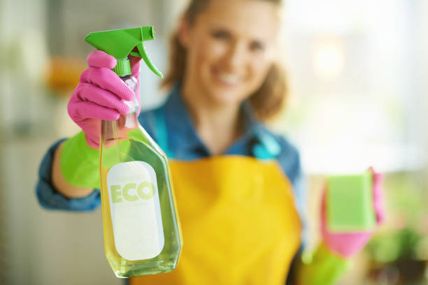 happy woman with sponge showing cleaning agent stock photo