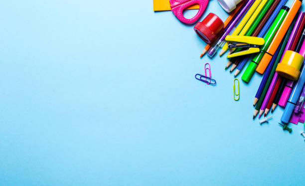 istock Bright diverse stationery lie on a blue background, leaving room for text 1242154165