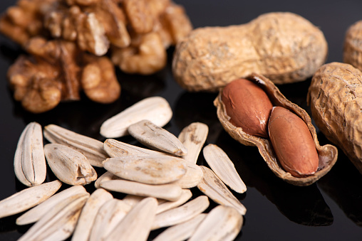 Sun Flower Seed, Peanut And Walnut On Black Background