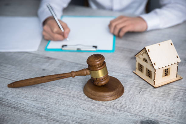 istock man hand document with judge and house model 1242159503