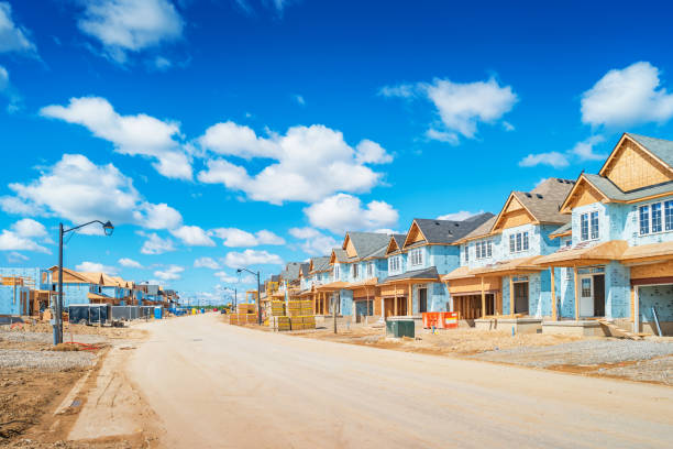 Housing development in a new neighborhood Houses are under construction in a new residential district on a sunny day. housing development stock pictures, royalty-free photos & images
