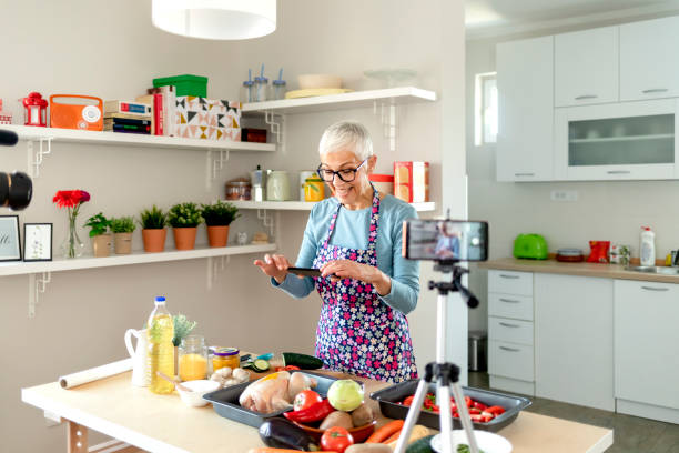 istock Senior woman making cooking vlog, recording herself on camera 1242182093