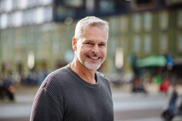 pria berambut abu-abu dewasa melihat kamera dan tersenyum - amsterdam foto potret stok, foto, & gambar bebas royalti