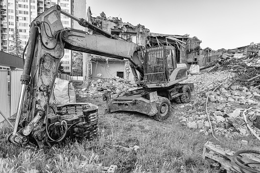 Excavator before demolish old building. City reconstruction. Black and white. Construction Machinery