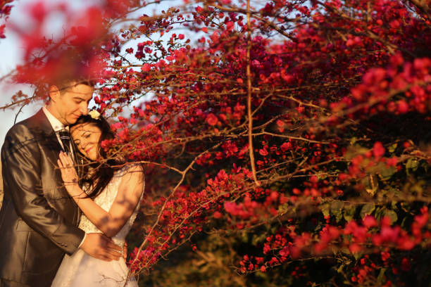 istock Groom and bride near red flower 1242189646