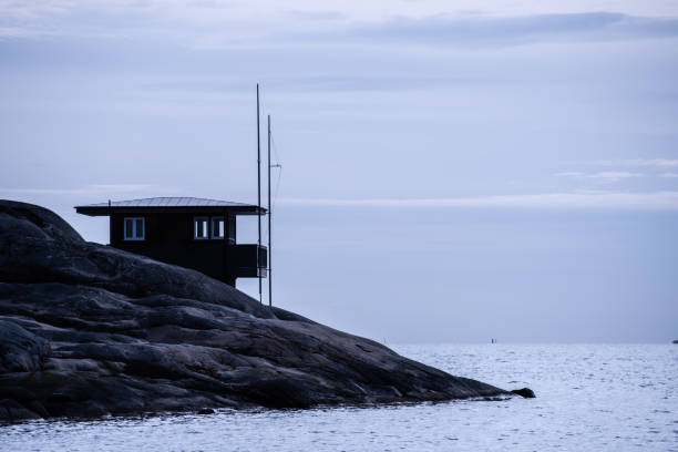 istock Silhouette of small house on cliffs by the sea. 1242199856