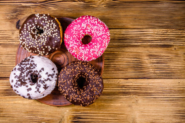 istock Plate with glazed donuts on a wooden table. Top view 1242206940