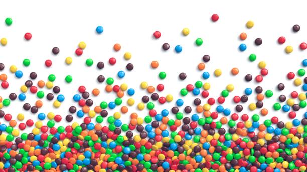 doces de chocolate revestidos coloridos espalhados no fundo branco - sweet food sugar vibrant color multi colored - fotografias e filmes do acervo
