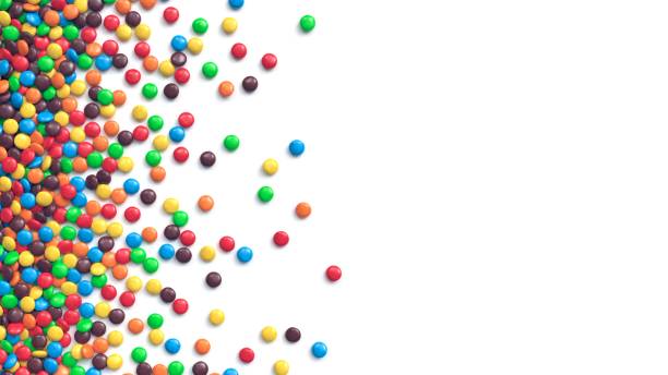 istock Colorful coated chocolate candies scattered on white background 1242217380
