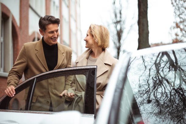 Ladies first Handsome guy is opening the door of the car to his woman. georgijevic frankfurt stock pictures, royalty-free photos & images