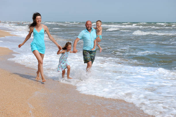 istock Happy family running on beach. 1242248515