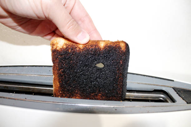 istock hand pulling a burnt toast out of the toaster 1242255357
