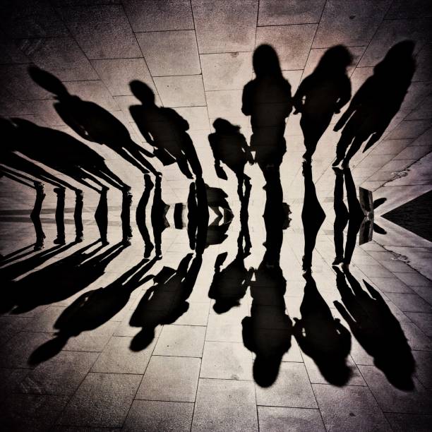 istock Reflection view of the group of people shadows 1242275224