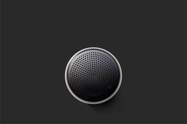 Top view of small wireless Bluetooth speaker on a dark surface. Music player viewed from above with dotted grille. Black Wireless Bluetooth Speaker Isolated on Plain Black Background, Viewed From Above; Top View Showing Perforated Metal Grille Holes. metal grate photos stock pictures, royalty-free photos & images