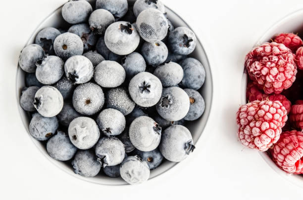 istock Frozen blueberries and raspberries on a white background. 1242348009