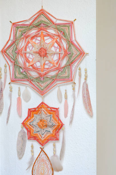 istock Closeup dreamcatcher with two God's eye mandalas and feathers on wall background 1242353698