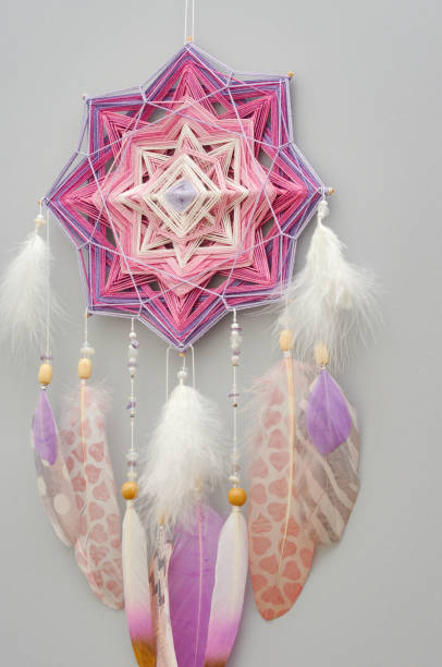 istock Mandala dream catcher with feathers and amethyst beads on grey background 1242355251