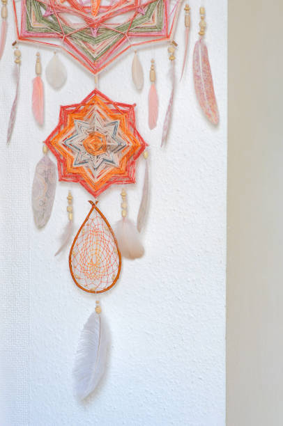 istock Closeup dreamcatcher with two God's eye mandalas and feathers on wall background 1242367285