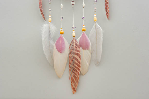 istock Feathers and amethyst beads on grey background 1242367804