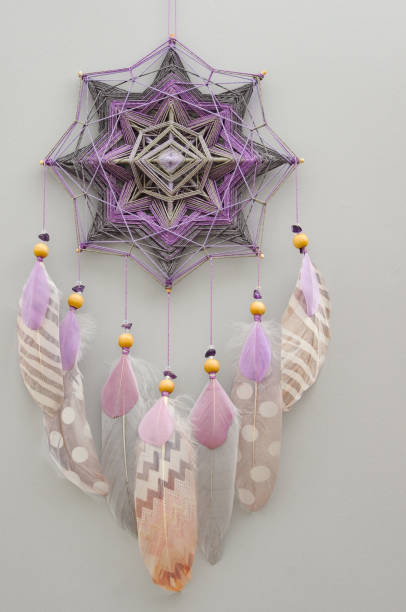 istock Mandala dream catcher with feathers and amethyst beads on grey background 1242368322